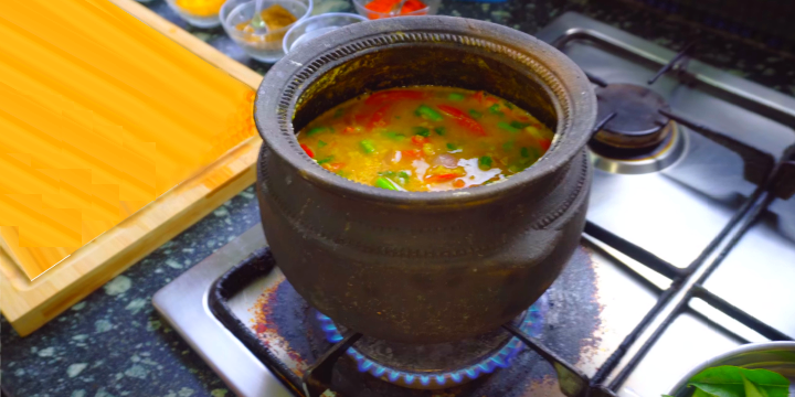 A vegetarian Hindu Standards Sambar Dal (lentils curry) being cooked in an earthen pot, that perserves natural aroma and micronutrients.